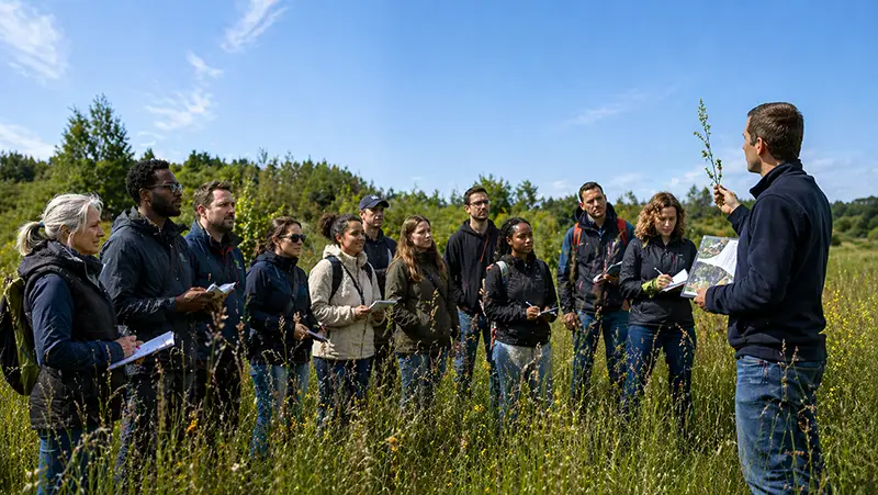 Groupe en formation végétale devant formateur montrant une espèce exotique envahissante